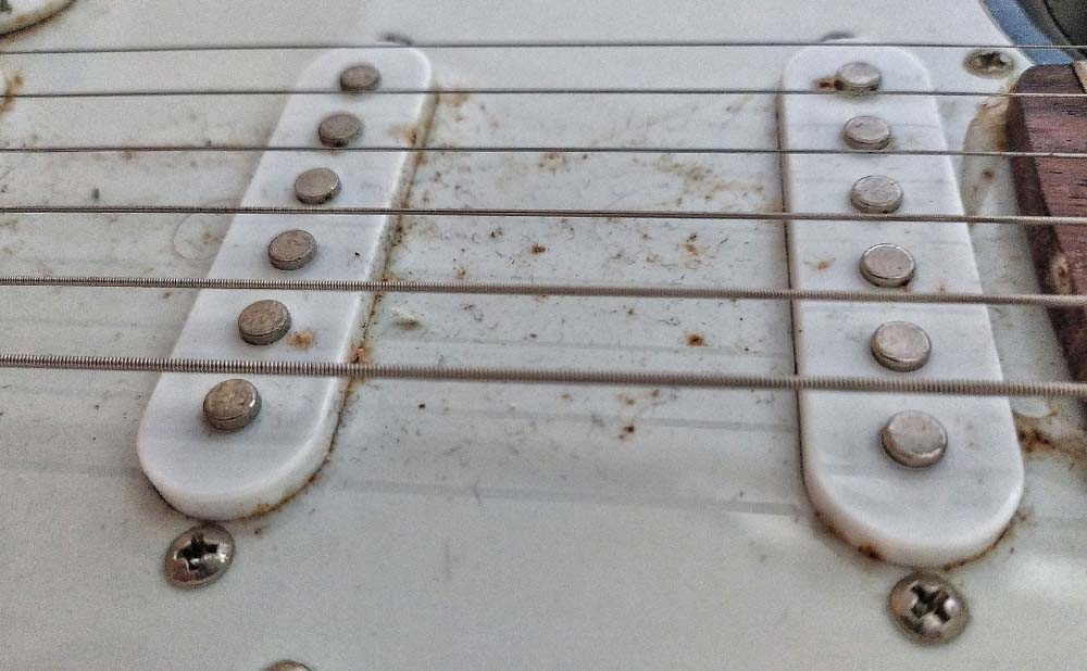 Oxidation der Metallumspinnung einer Gitarrensaite durch Feuchtigkeit und Salze